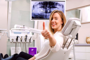 Patientin in Zahnarztpraxis zeigt Daumen nach oben